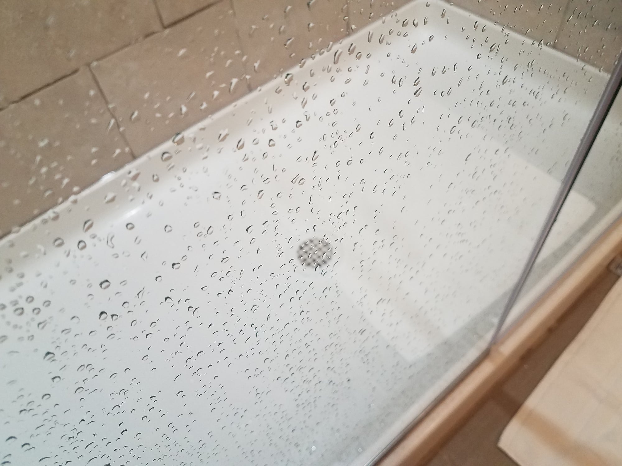 Shower pan leak in bathroom requiring repair.