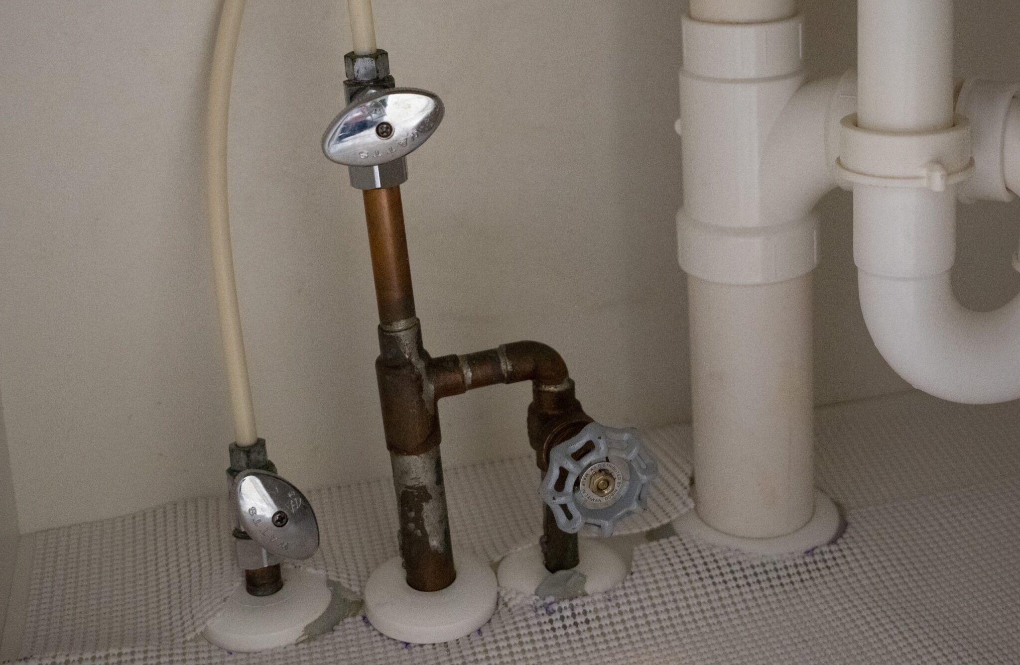 Fixture shutoff valves under the kitchen sink.